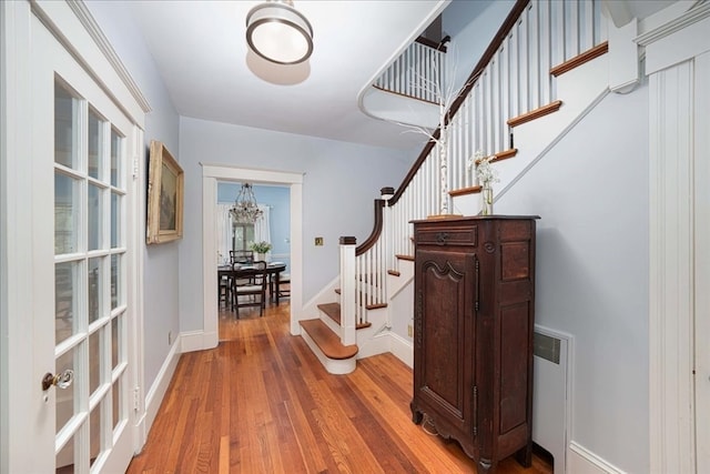 interior space featuring a notable chandelier, hardwood / wood-style floors, and radiator heating unit