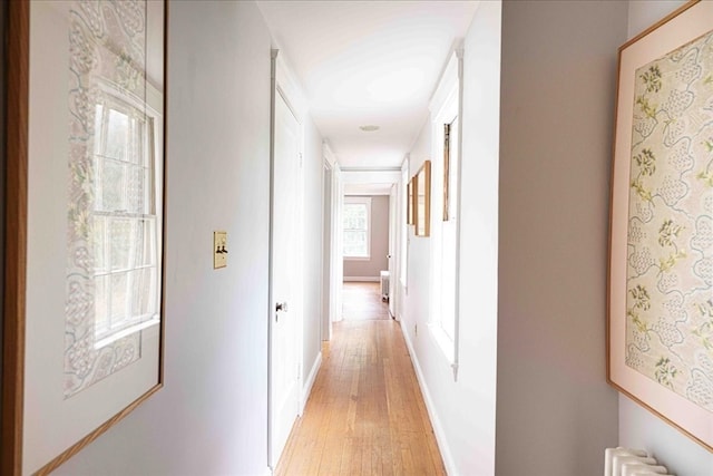 hallway featuring radiator and light hardwood / wood-style floors