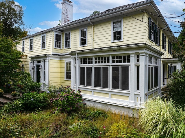 back of property with a sunroom