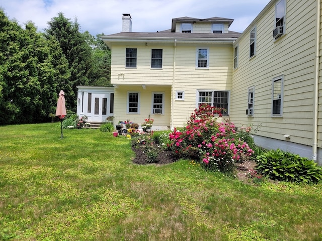 rear view of property with a lawn