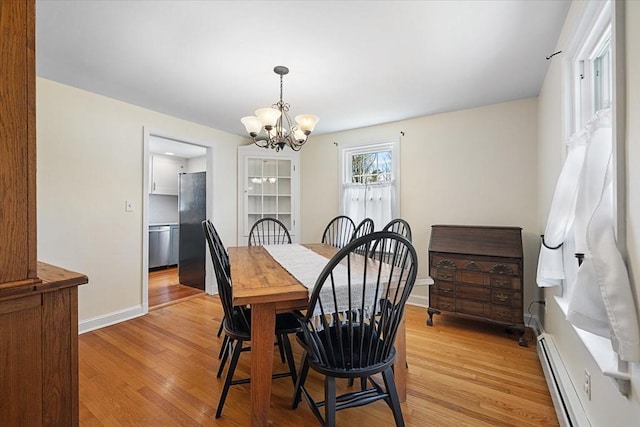 dining room featuring baseboards, an inviting chandelier, baseboard heating, and light wood-type flooring