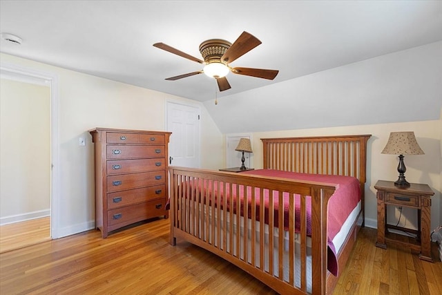 bedroom with ceiling fan, baseboards, vaulted ceiling, and wood finished floors