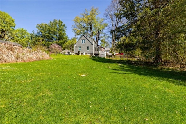 view of yard featuring fence and a deck