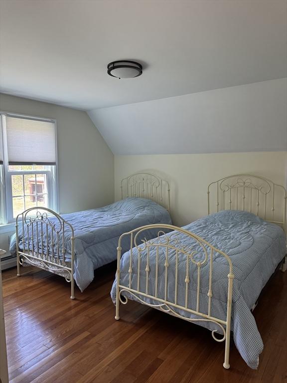 bedroom with vaulted ceiling and wood finished floors