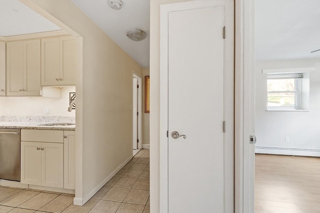 hall featuring light tile patterned floors, sink, and baseboard heating