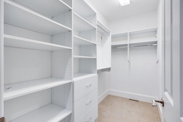 walk in closet with light colored carpet