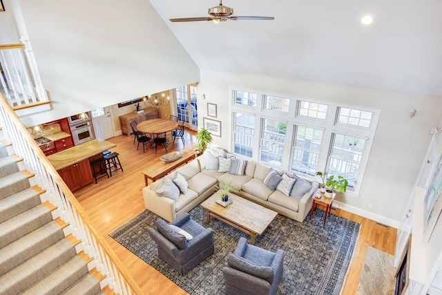 living room featuring ceiling fan, wood-type flooring, and high vaulted ceiling