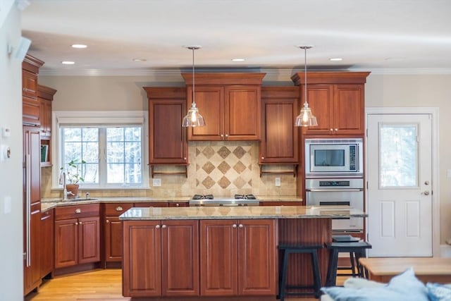 kitchen featuring stainless steel appliances, light stone countertops, and pendant lighting