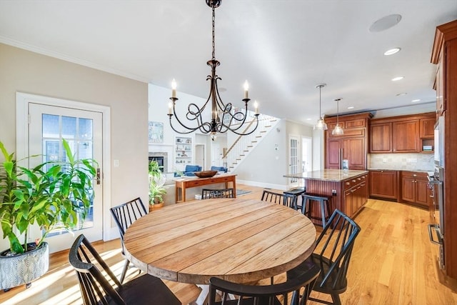 dining room featuring crown molding, a chandelier, and light hardwood / wood-style floors