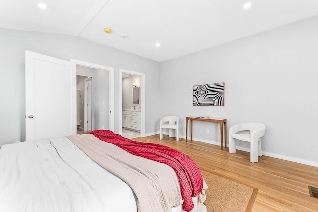 bedroom with connected bathroom and hardwood / wood-style floors