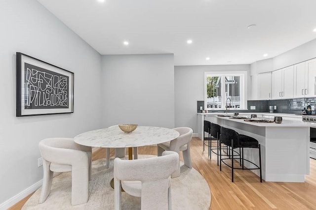 dining space with sink and light wood-type flooring