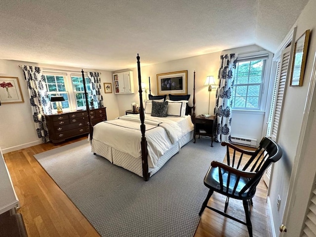 10 Granada Way, Andover, MA 01810 - bedroom with a textured ceiling, a baseboard radiator, multiple windows, wood finished floors, and lofted ceiling