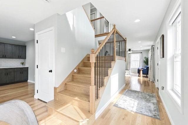 stairs with recessed lighting, baseboards, ceiling fan, and wood finished floors