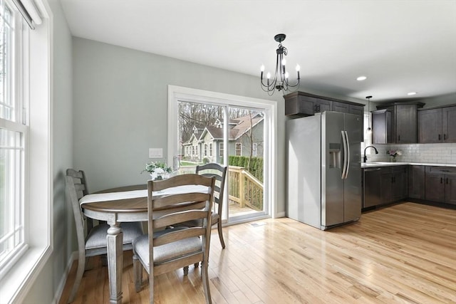 dining room featuring an inviting chandelier, recessed lighting, and light wood-style flooring