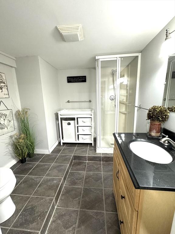 12 Bonin Dr, Haverhill, MA 01832 - bathroom with vanity, toilet, a stall shower, and baseboards
