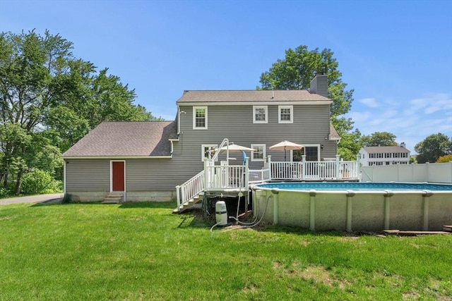 12 Bonin Dr, Haverhill, MA 01832 - rear view of house with entry steps, a chimney, a lawn, a wooden deck, and an outdoor pool