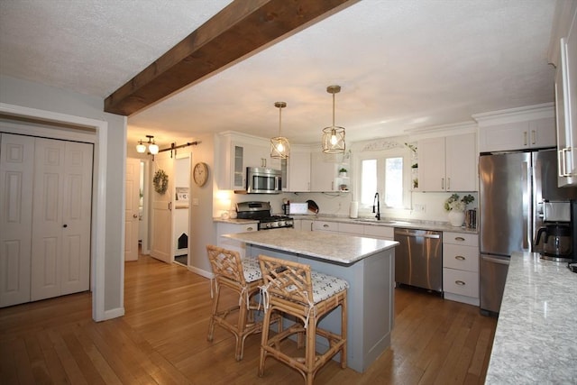 12 Bonin Dr, Haverhill, MA 01832 - kitchen featuring stainless steel appliances, a sink, dark wood-type flooring, white cabinets, and a center island
