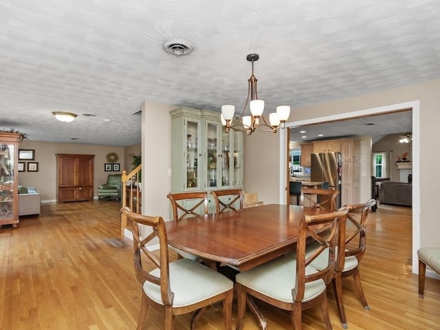 48 Twin Brook Ln, Taunton, MA 02780 - dining area featuring a chandelier, light wood-style flooring, a textured ceiling, stairway, and baseboards