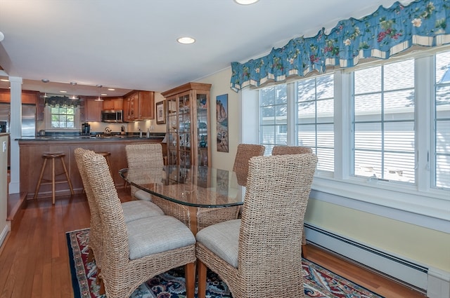 dining area with a baseboard radiator and dark hardwood / wood-style flooring