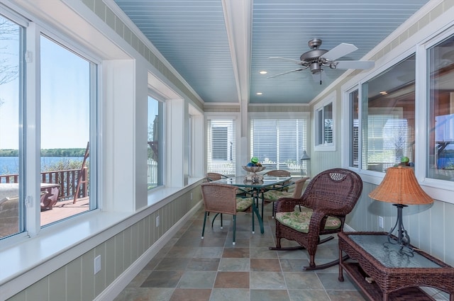 sunroom with beamed ceiling, ceiling fan, and a wealth of natural light