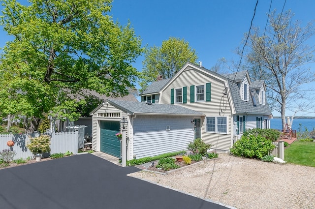 view of front of house featuring an outdoor structure, a garage, and a water view