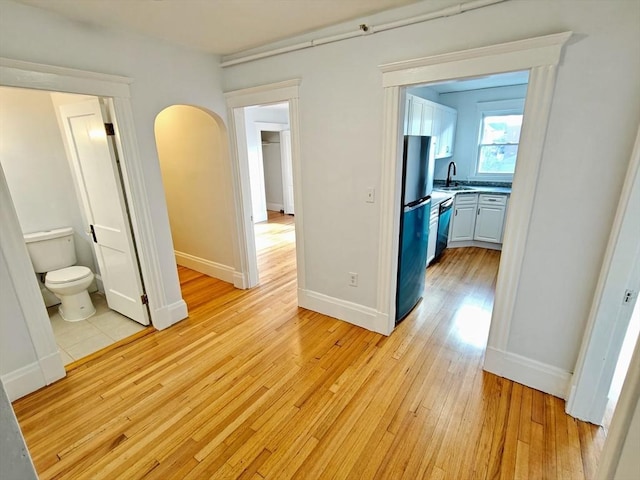 hallway with sink and light wood-type flooring