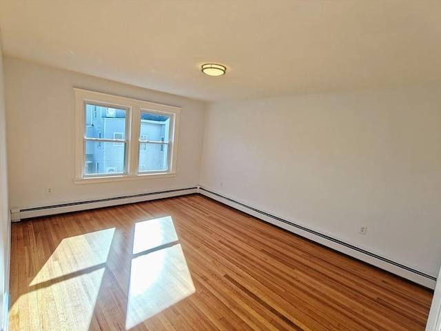 spare room featuring a baseboard radiator and light hardwood / wood-style flooring