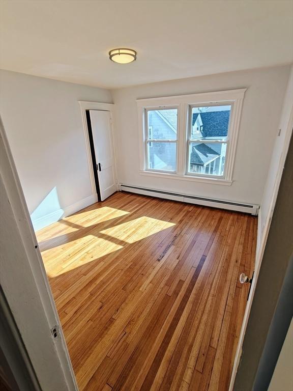 empty room featuring light hardwood / wood-style flooring and a baseboard radiator