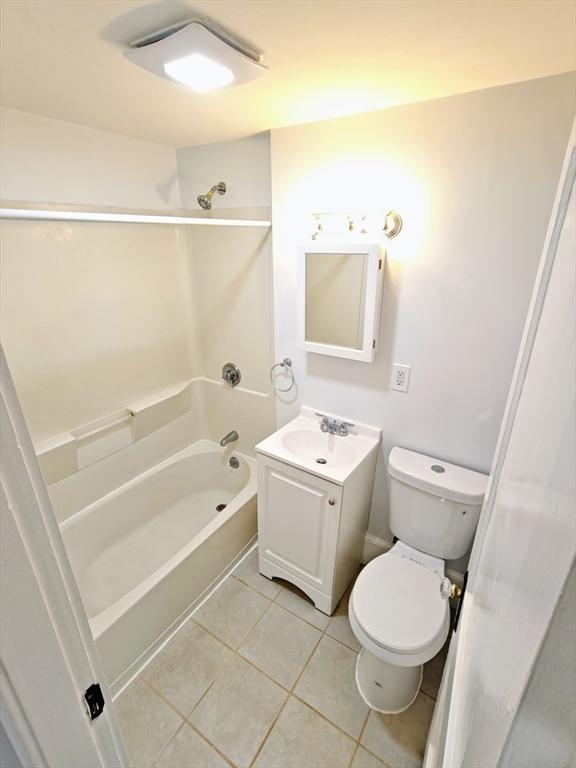 full bathroom featuring shower / bath combination, vanity, tile patterned floors, and toilet