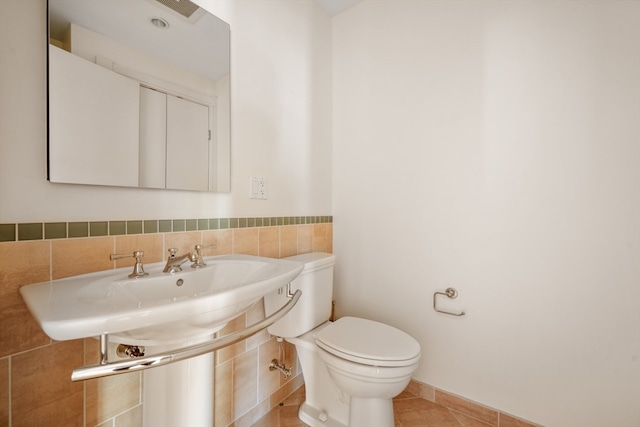 bathroom featuring tile patterned flooring, tile walls, toilet, and backsplash