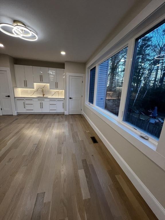 1 Harvard Ave, Burlington, MA 01803 - kitchen featuring wood finished floors, light countertops, white cabinets, and recessed lighting