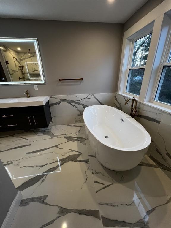 1 Harvard Ave, Burlington, MA 01803 - full bath with vanity, wainscoting, a soaking tub, tile walls, and marble tiled flooring