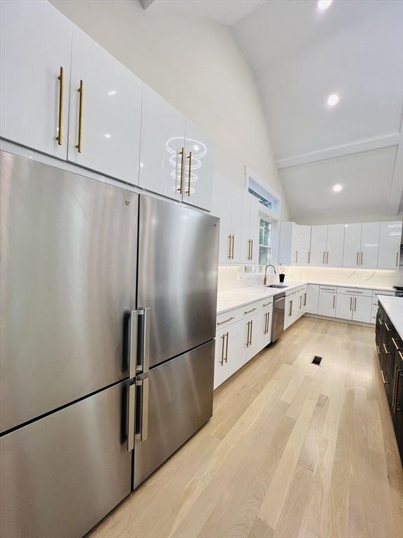 1 Harvard Ave, Burlington, MA 01803 - kitchen with appliances with stainless steel finishes, high vaulted ceiling, white cabinets, light countertops, and light wood-type flooring