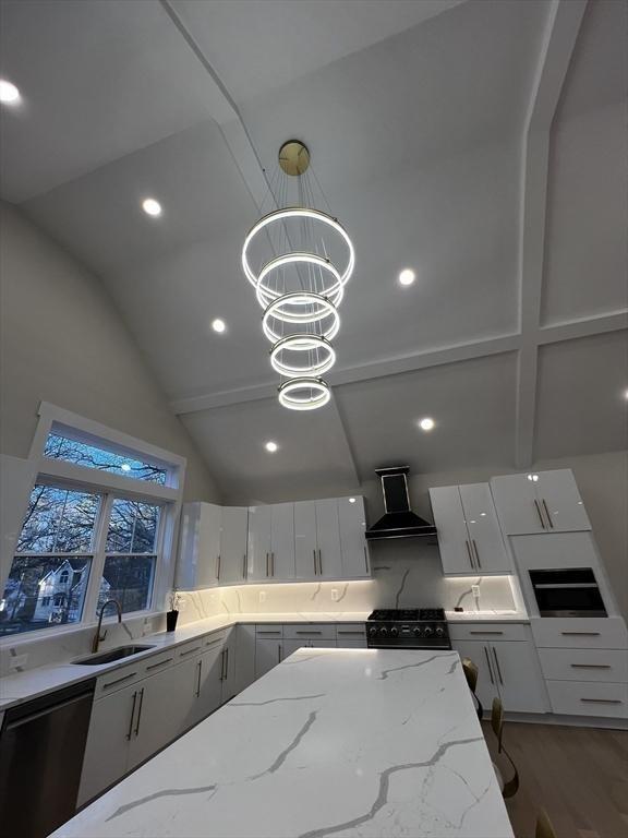 1 Harvard Ave, Burlington, MA 01803 - kitchen with wall chimney range hood, black gas range, high vaulted ceiling, light stone countertops, and light wood-style floors