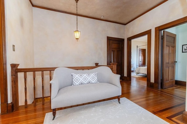 sitting room with crown molding, baseboards, and wood finished floors