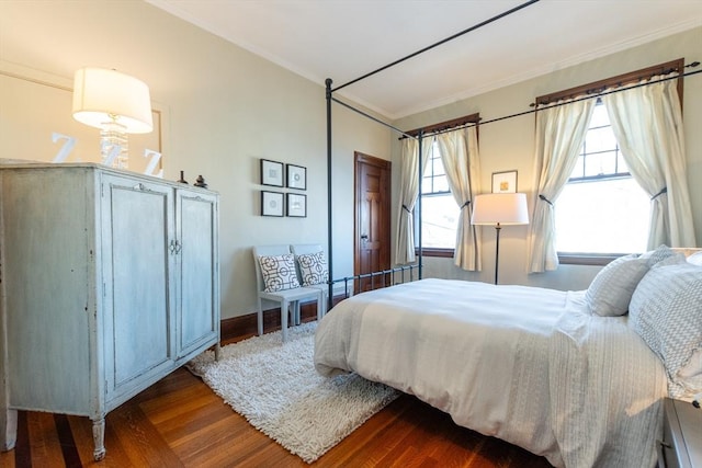 bedroom with ornamental molding and wood finished floors