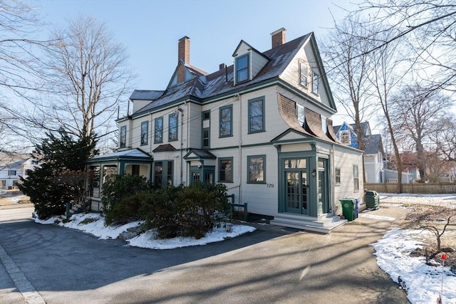 view of front of house featuring a chimney and fence