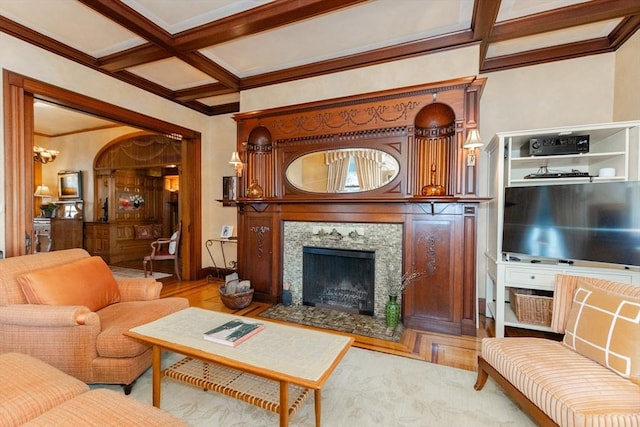 living room with coffered ceiling, a premium fireplace, wood finished floors, crown molding, and beam ceiling