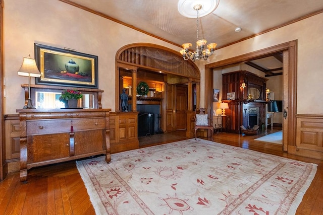 dining space with ornamental molding, a notable chandelier, a fireplace, and hardwood / wood-style floors