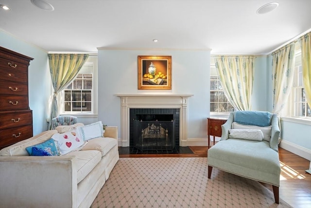 living area with hardwood / wood-style flooring, a fireplace, and crown molding