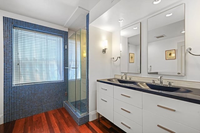 bathroom with walk in shower, vanity, and hardwood / wood-style floors