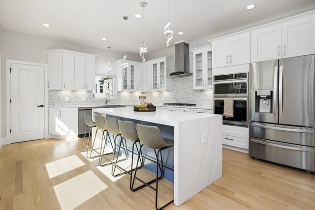 45 Sargent Ave, Somerville, MA 02145 - kitchen with appliances with stainless steel finishes, wall chimney exhaust hood, tasteful backsplash, a kitchen island, and recessed lighting