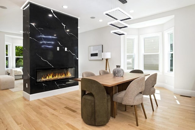 45 Sargent Ave, Somerville, MA 02145 - dining area with light wood-type flooring, a premium fireplace, baseboards, recessed lighting, and a chandelier