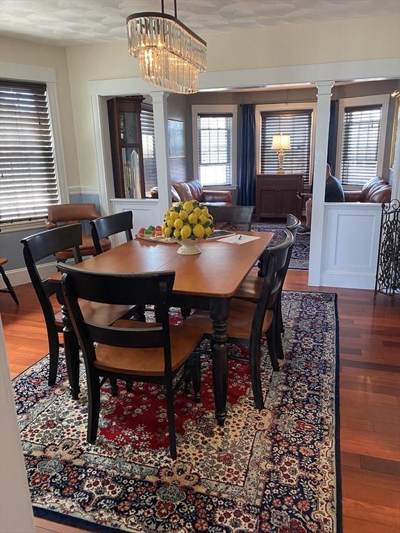 876 Shirley Unit 1, Winthrop, MA 02152 - dining area with ornate columns, wood finished floors, plenty of natural light, and a chandelier