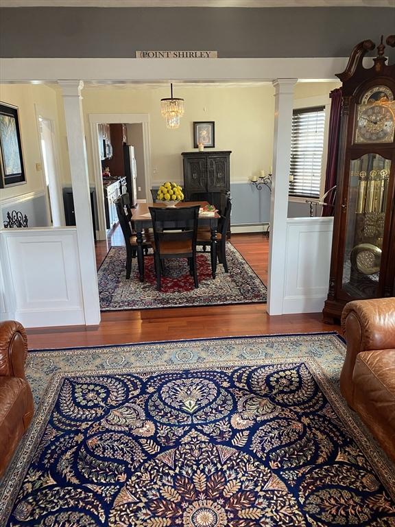 876 Shirley Unit 1, Winthrop, MA 02152 - dining room with wood finished floors, decorative columns, and baseboard heating
