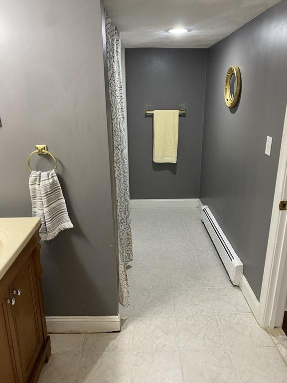 876 Shirley Unit 1, Winthrop, MA 02152 - full bathroom featuring baseboard heating and vanity