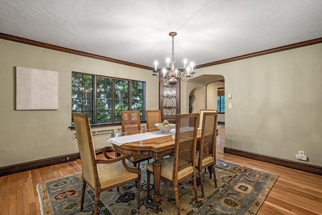 170 Atlantic Ave, Swampscott, MA 01907 - dining space featuring arched walkways, a chandelier, wood-type flooring, and crown molding