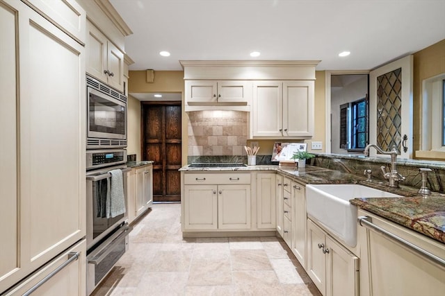 170 Atlantic Ave, Swampscott, MA 01907 - kitchen featuring stainless steel appliances, a warming drawer, decorative backsplash, cream cabinetry, and recessed lighting