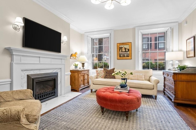 living room featuring wood finished floors, a high end fireplace, and ornamental molding