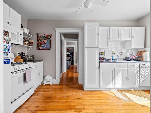 kitchen with light wood-type flooring, white appliances, backsplash, and white cabinets